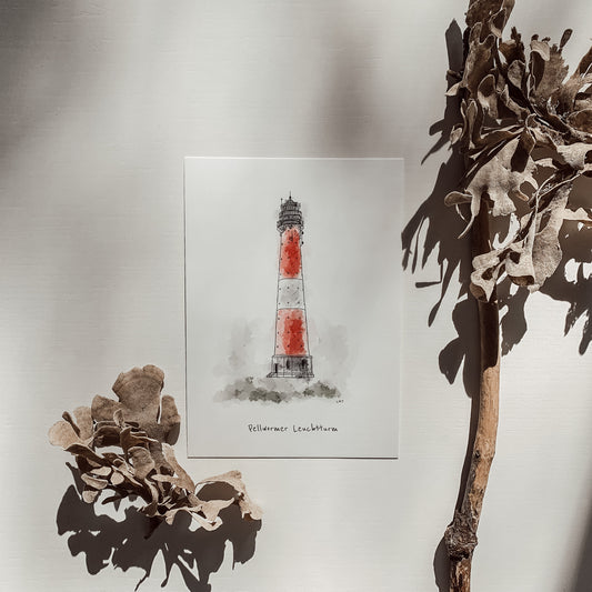 Postkarte des roten und weißen Leuchtturms von Pellworm, platziert auf einer weißen Karte, dekoriert mit getrockneten Pflanzen und Treibholz im Hintergrund.