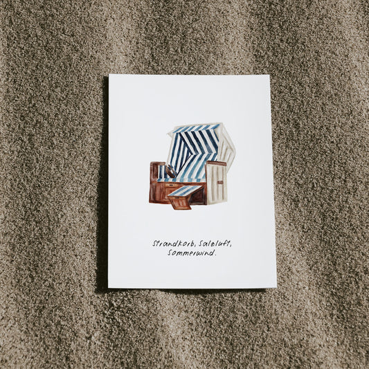Maritime Postkarte mit Strandkorb-Illustration – mit folgendem Spruch "Strandkorb, Salzluft, Sommerwind" aufgenommen am Strand für echtes Nordsee-Feeling. Perfekt als Deko, Geschenk oder Urlaubsgruß. Jetzt bei Saltwaterdesigns.