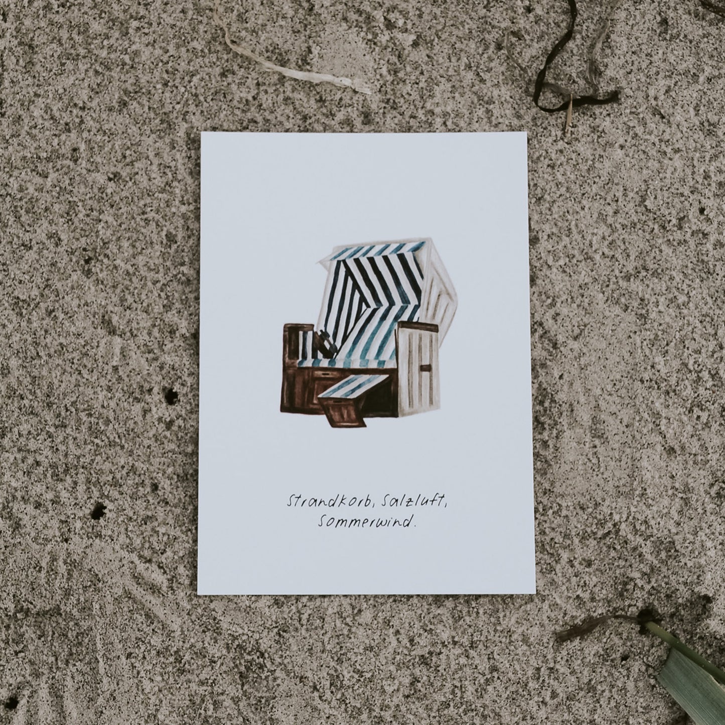 Postkarte mit handgemalter Strandkorb-Illustration in Blau-Weiß, zeigt die frontale Ansicht. Maritime Postkarte von Saltwaterdesigns, inspiriert von der Nordsee.