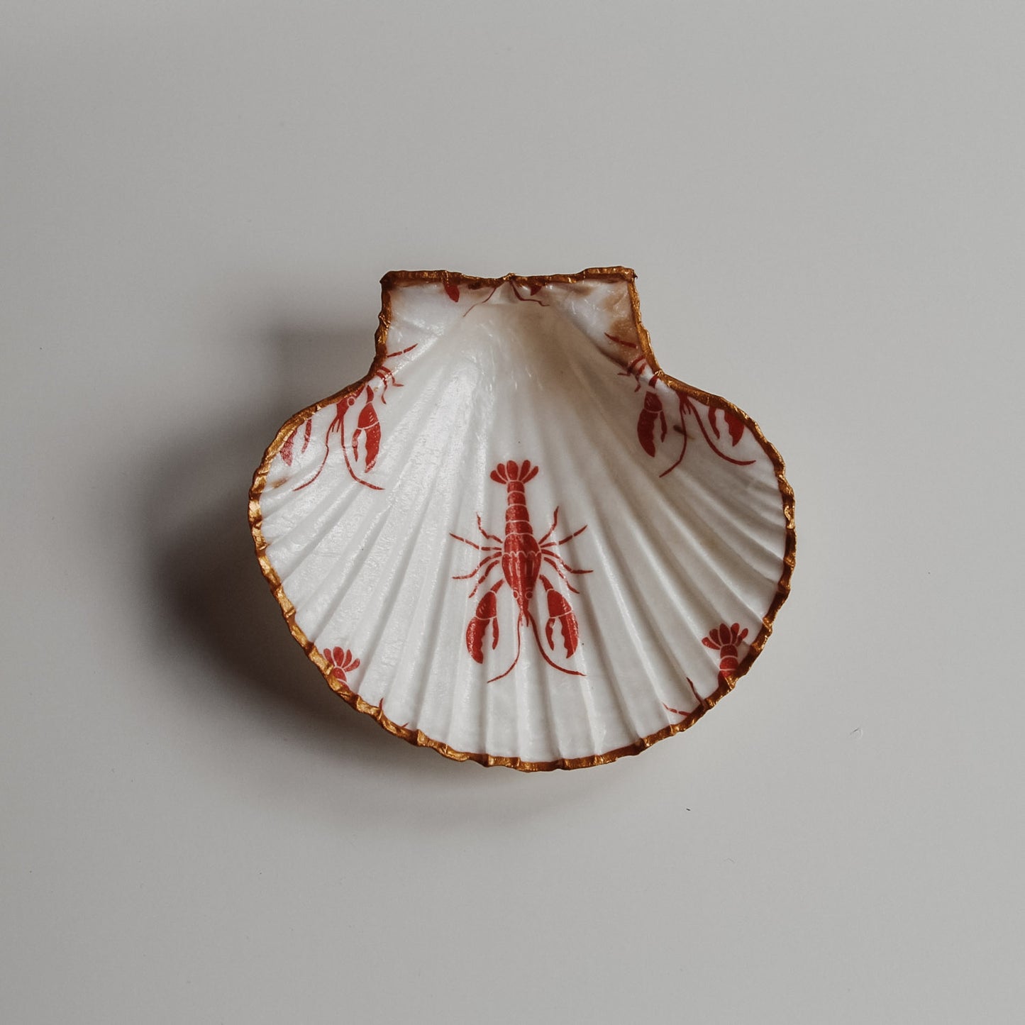 Muschelschale mit rotem Hummer-Design und goldenem Rand – dekorative Schmuckschale von saltwaterdesigns.
