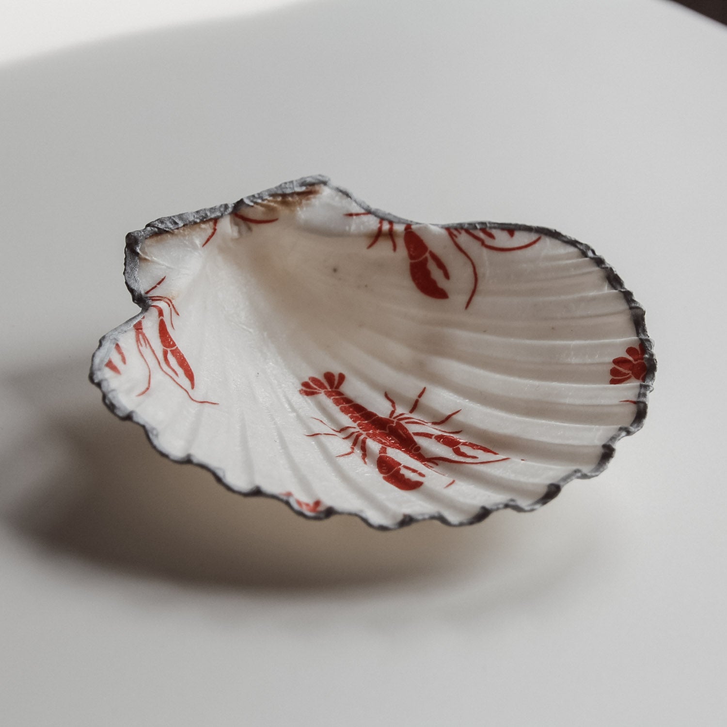 Schlichte dekorative Schmuckschale. Von saltwaterdesigns. Mit rotem Hummer-Design. Und silberfarbenem Rand.