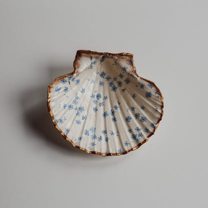 Diese dekorative Schmuckschale stammt von Saltwater Designs.
Die Schale ist mit einem blauen Blumenmuster verziert.
Sie verfügt über einen goldenen Rand.