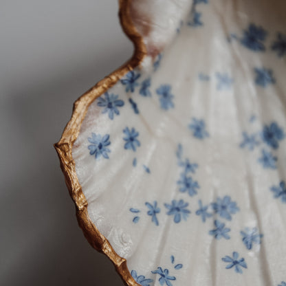 Detailaufnahme der Muschelschale Blomma von saltwaterdesigns. Viele kleine blaue Blümchen die sich über die ganze Muschel verteilen.