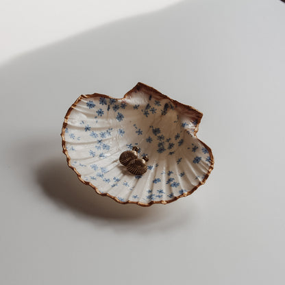 Dekorative Muschelschale mit blauem Blumen Design und goldenem Rand, gefüllt mit goldenen Ohrringen. Handgemacht von saltwaterdesigns.