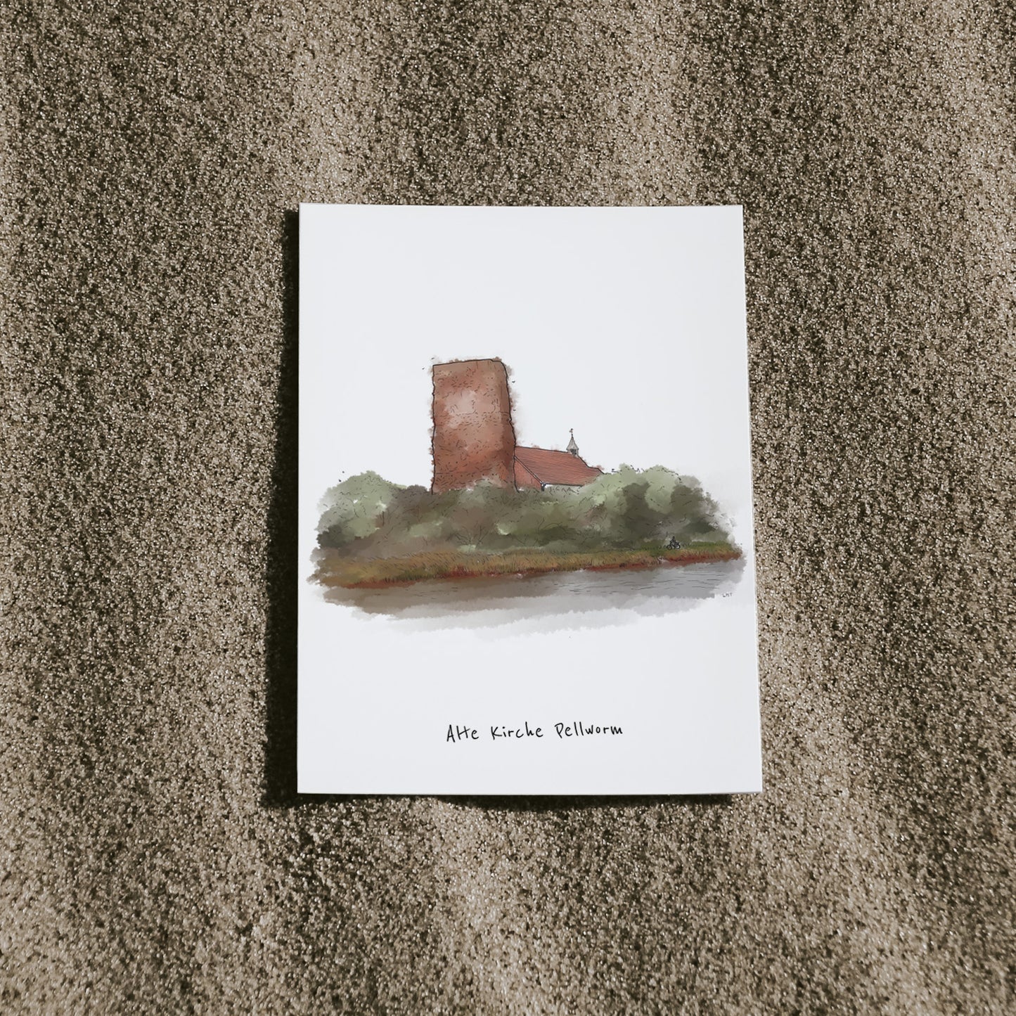 Postkarte mit Illustration der „Alten Kirche Pellworm“, arrangiert auf Sand. Die alte Kirche ist eine besondere Sehenswürdigkeit auf der Nordseeinsel Pellworm.