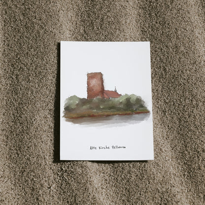 Postkarte mit Illustration der „Alten Kirche Pellworm“, arrangiert auf Sand. Die alte Kirche ist eine besondere Sehenswürdigkeit auf der Nordseeinsel Pellworm.