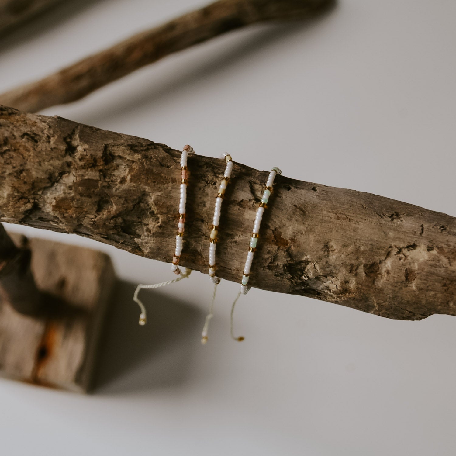 Übersicht von den drei Pearl Armbändern auf einem Strandgut-Schmuckständer von saltwaterdesigns.  Es gibt die Farben rosa, blau und gelb. Leicht zum Verstellen, gute Qualität.