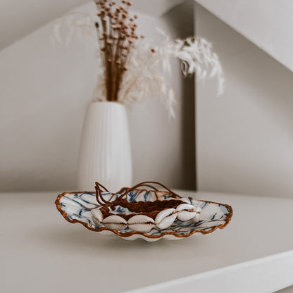 Kauri Muschelarmband liegt auf einer der Muriwai Schmuckschale von saltwaterdesigns. Platziert auf weißem Schrank, im Hintergrund Trockenblumen und wird gezeigt als Deko-Beispiel.