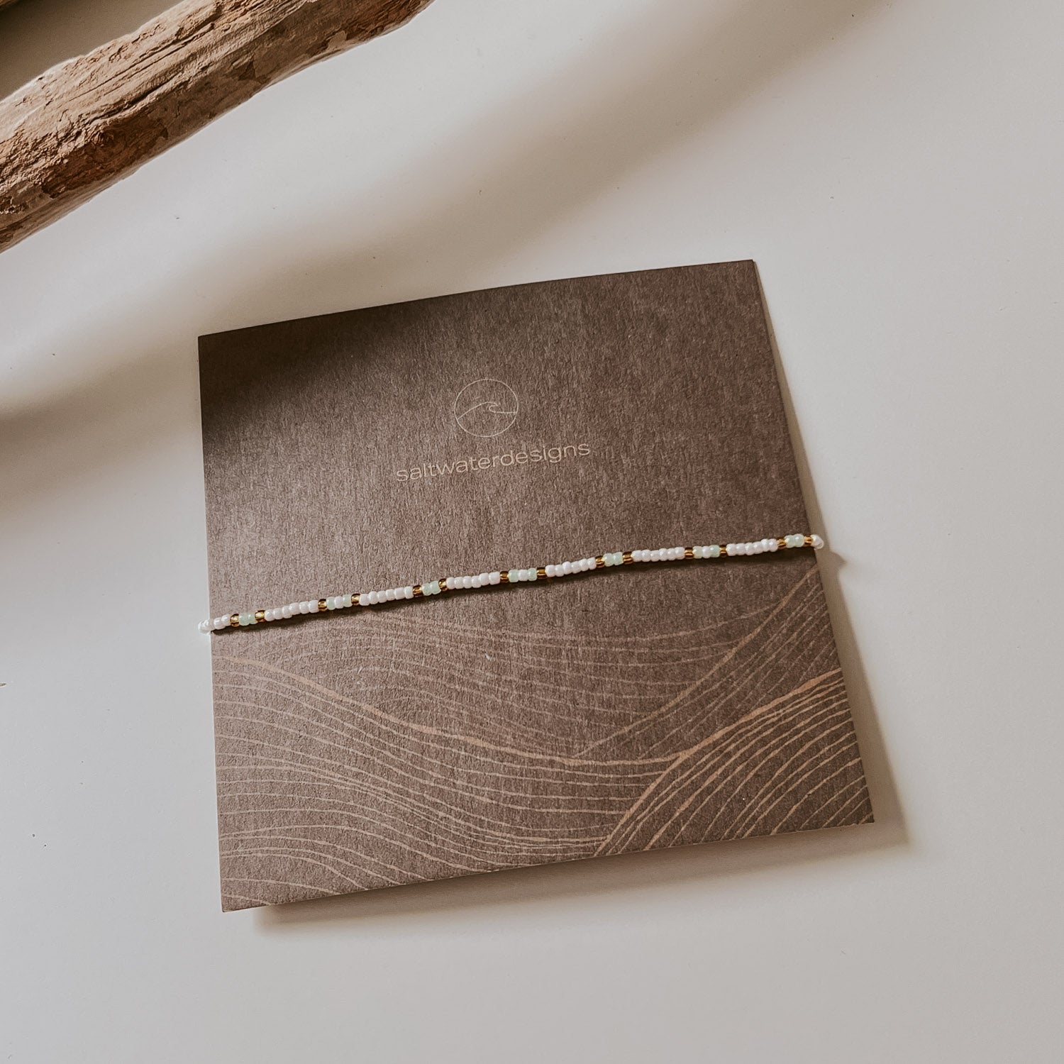 Ansicht von der Schmuckverpackung. Eine quadratische Karte, auf der ein einzelnes Armband zu sehen ist.