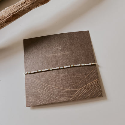 Ansicht von der Schmuckverpackung. Eine quadratische Karte, auf der ein einzelnes Armband zu sehen ist.