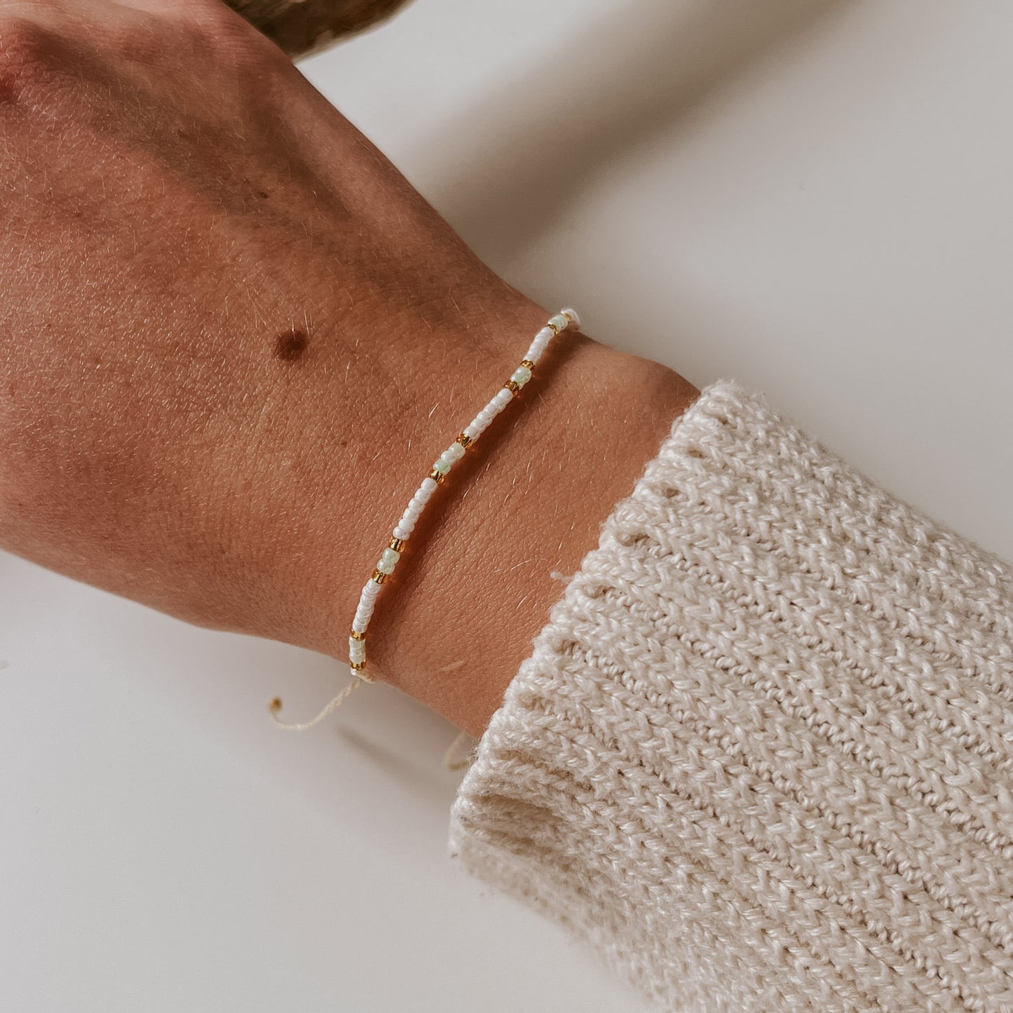 Pearl Armband mit leichter Akzentfarbe blau und goldenen Perlen. Schlichtes Perlenarmband, einfache Handhabung um die Größe zu verstellen. Armband von saltwaterdesigns.