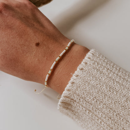 Pearl Armband mit leichter Akzentfarbe blau und goldenen Perlen. Schlichtes Perlenarmband, einfache Handhabung um die Größe zu verstellen. Armband von saltwaterdesigns.