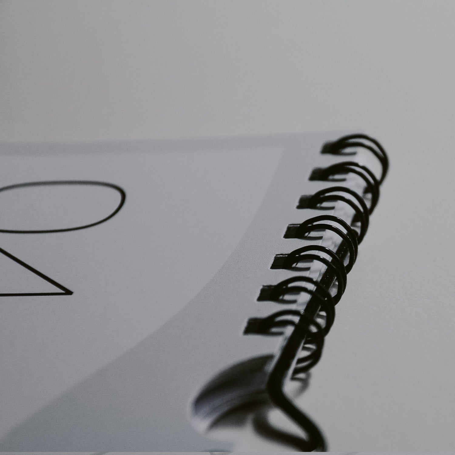 Nahaufnahme von der Ringheftung des Kalenders 2026 in schwarz matt. Hochwertige Verarbeitung mit 13 Blatt starken Papier.