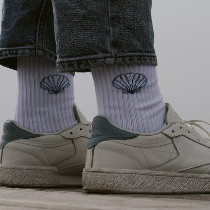 Rückansicht Saltwater Socken Muschel zu Jeans und weißen Sneakern, beide Muschel Designs sichtbar.