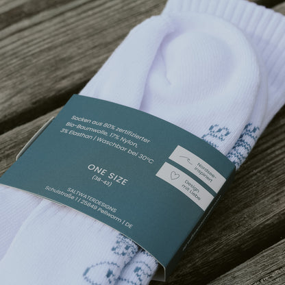 Rückseite der saltwaterdesigns Banderole mit Materialangaben: aus 80% zertifizierter Bio-Baumwolle, 17% Nylon, 3% Elastan, One Size 38–43, Nordsee-inspiriert.
